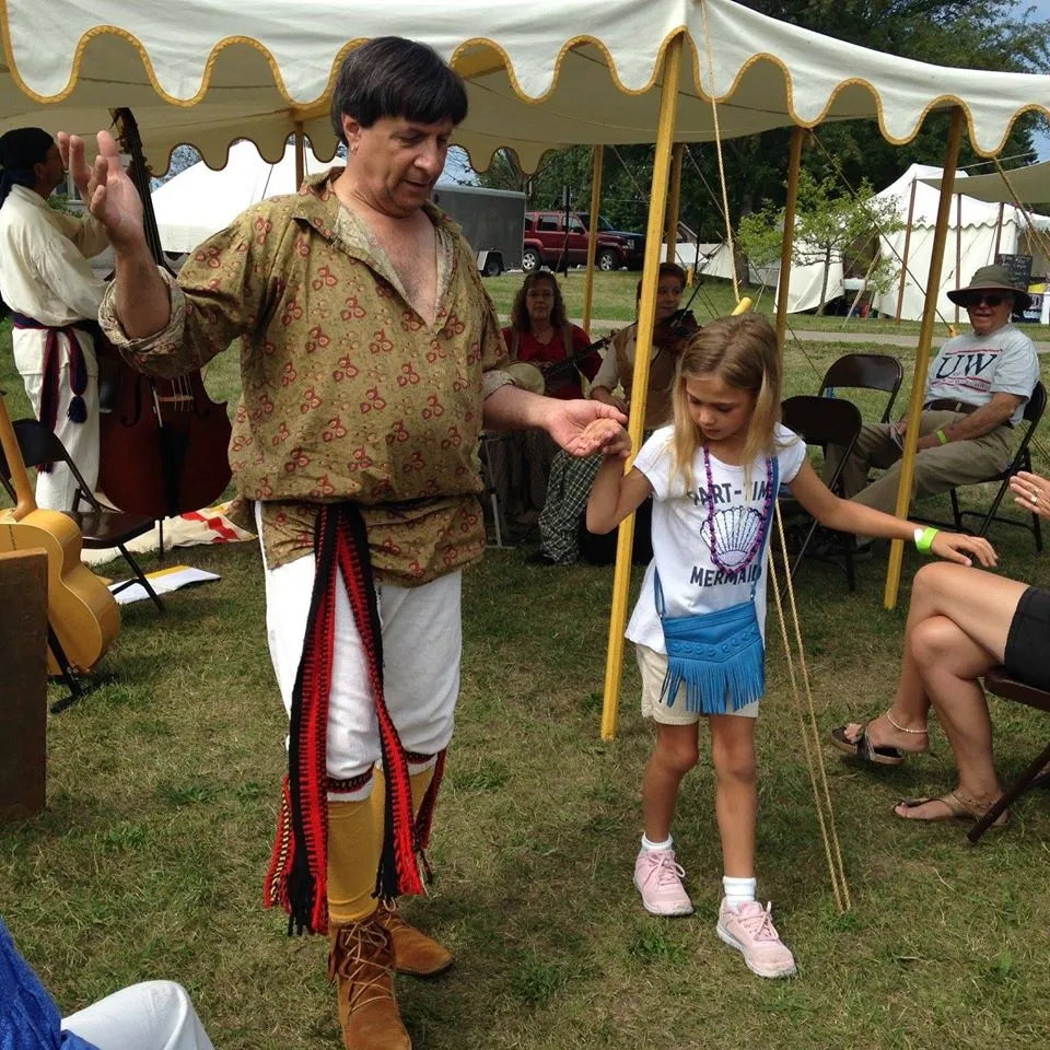 Genot Picor in period costume dancing with child at outdoor festival